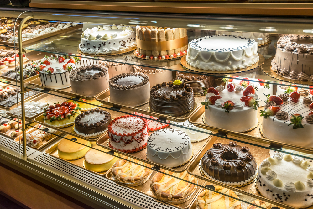 Bakery display case showing many different kinds of cake